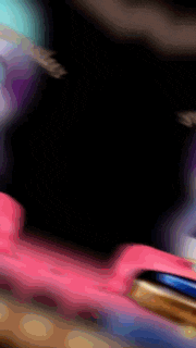 a close up of a pink object on a black background .