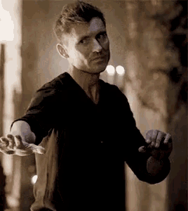 a man in a black shirt is reaching out towards something