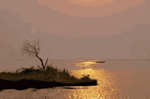 a small island in the middle of the ocean with a boat in the distance
