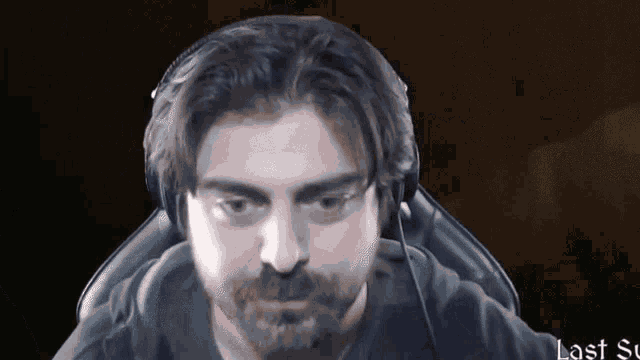 a man with a beard wearing headphones is sitting in a chair