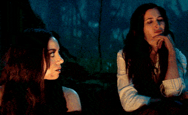 a woman in a white shirt stands next to another woman