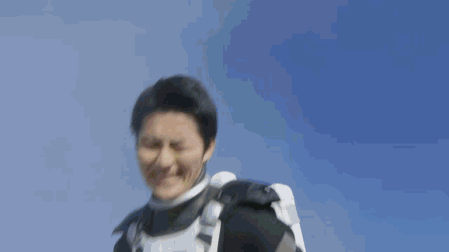 a blurry picture of a man in a superhero costume with a blue sky in the background
