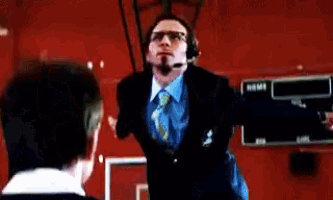 a man in a suit and tie is wearing a headset while talking to another man