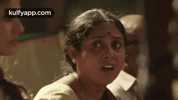 a woman is making a funny face while standing next to another woman in a room .