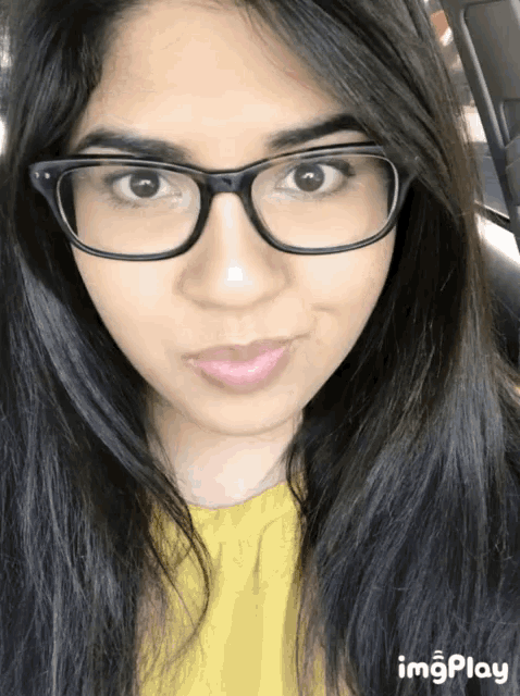 a close up of a woman wearing glasses and a yellow shirt with imgplay written on the bottom