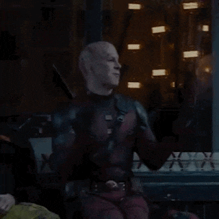 a man in a deadpool costume is clapping his hands in front of a window