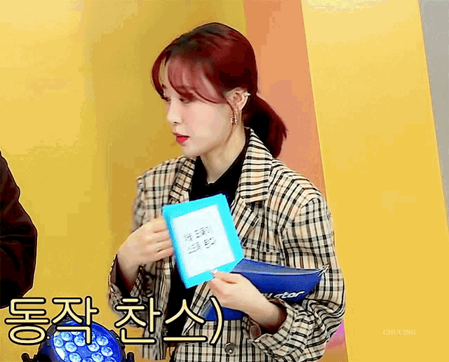 a woman in a plaid jacket is holding a piece of paper that says i star on it