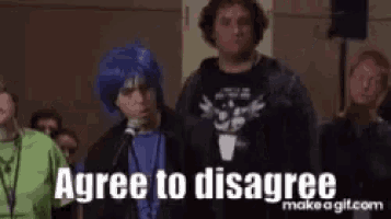 a man wearing a blue wig is standing in front of a microphone and saying `` agree to disagree '' .