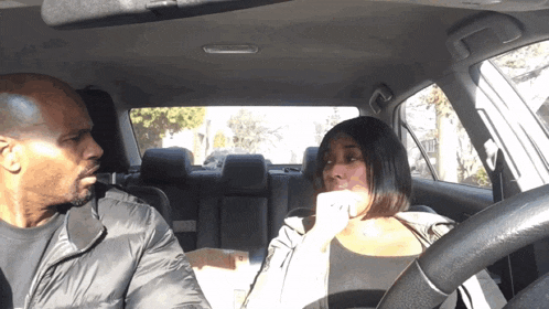 a man and a woman are sitting in a car talking to each other
