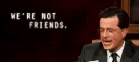 a man in a suit and tie is holding a piece of paper and pointing at the words we 're not friends .