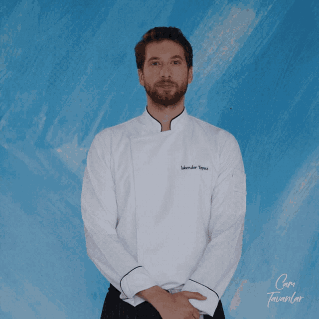 a man wearing a chef 's jacket with the name iskender topuz