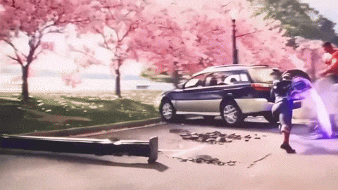 a car is parked on the side of the road in front of a park with cherry blossoms