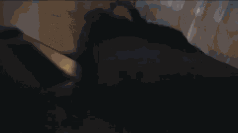 a person laying on a bed with a black blanket