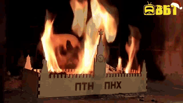 a model of a clock tower is on fire with the letters pth and phx written on it