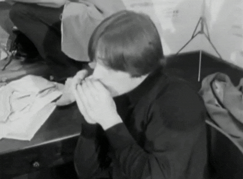 a black and white photo of a person covering their mouth