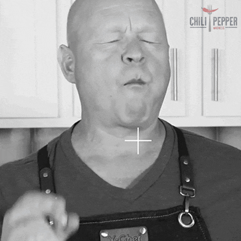 a man wearing an apron that says chili pepper