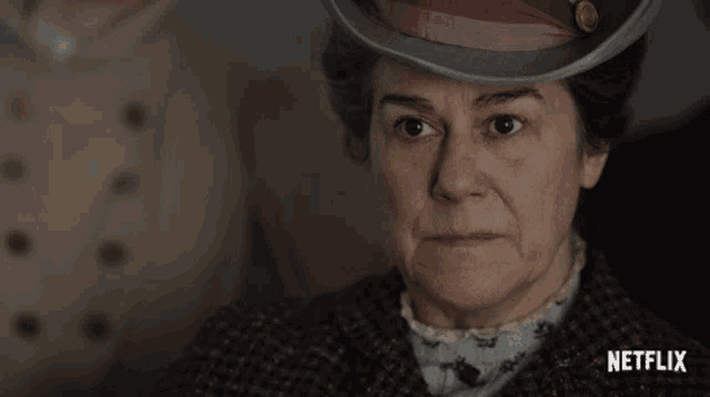 a woman wearing a hat with a netflix logo on the bottom right