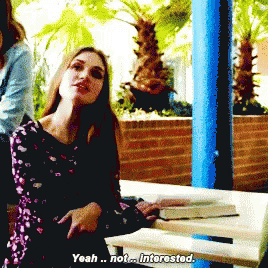 a woman is sitting at a picnic table and says yeah not interested