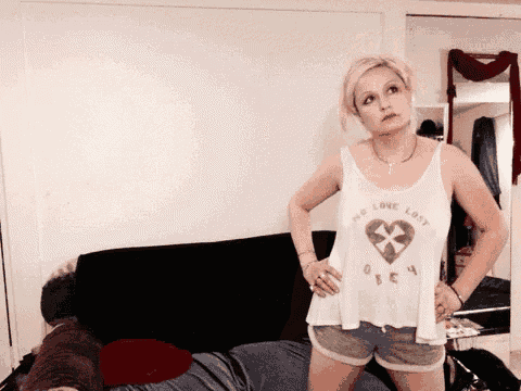 a woman wearing a white tank top that says no love lost