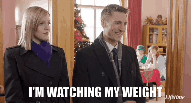 a man and a woman are standing next to each other and the man is saying i 'm watching my weight