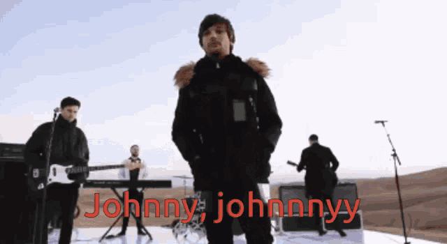 a man in a black jacket stands in front of a microphone with the words johnny johnny written on the bottom