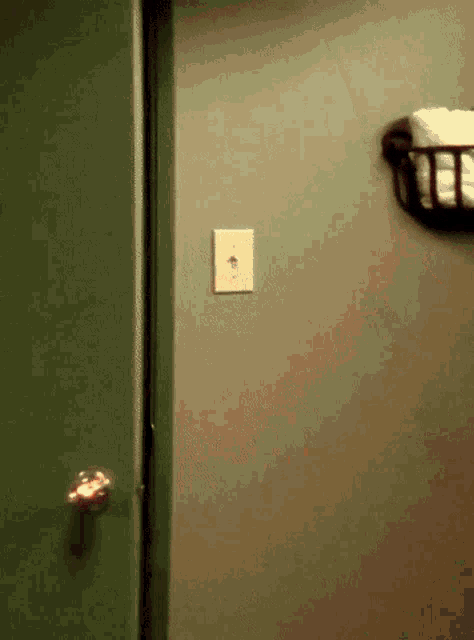 a light switch on the wall next to a basket of towels
