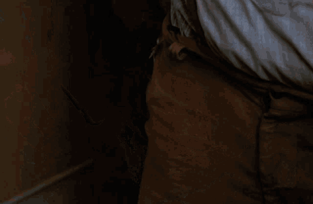 a man in a striped shirt is holding a knife in his right hand