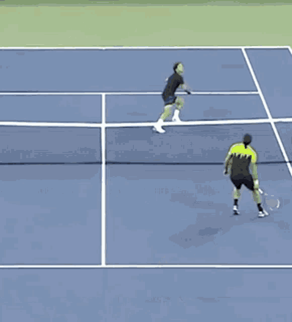 a man in a green shirt is walking on a tennis court holding a tennis racquet
