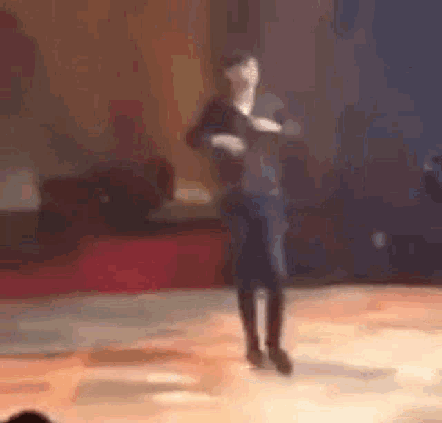 a woman is dancing on a stage in front of a crowd .