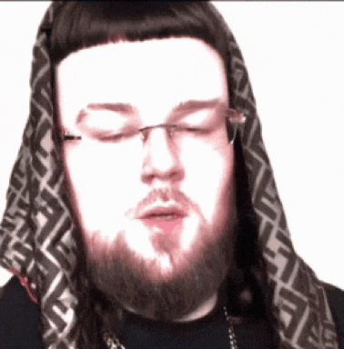a man with a beard wearing glasses and a scarf around his head with the letter f on it