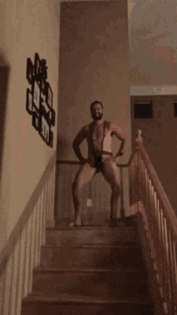 a shirtless man is standing on a set of wooden stairs