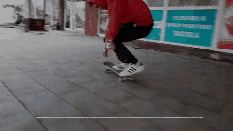 a person is riding a skateboard on a sidewalk in front of a building with a sign that says " televizyon "