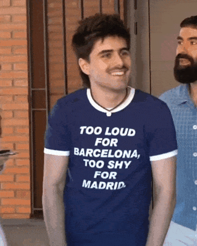 a man is wearing a blue shirt that says too loud for barcelona too shy for madrid