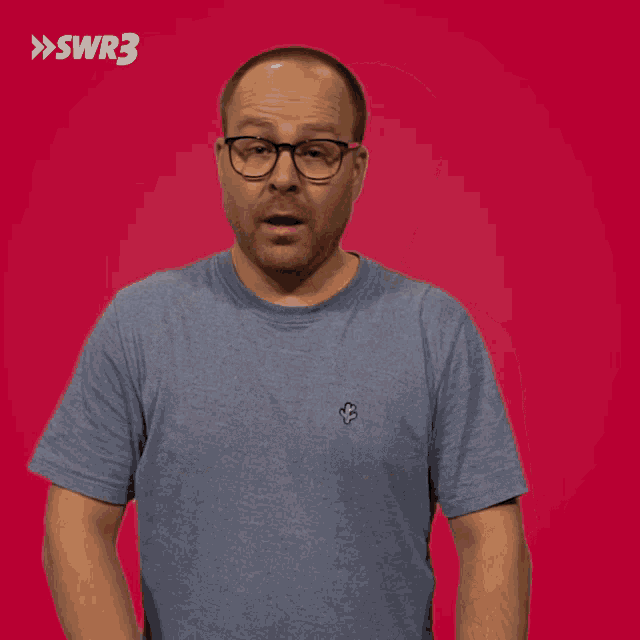 a man wearing glasses and a blue shirt with swr3 written on the bottom right