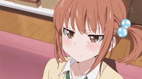 a girl with red hair and a blue bow in her hair is looking at the camera .
