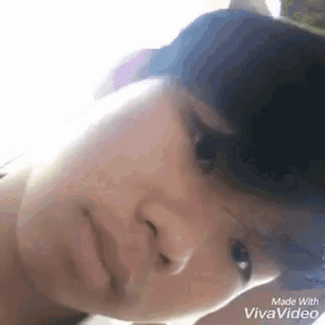 a close up of a person 's face with a blurred background made with vivavideo .