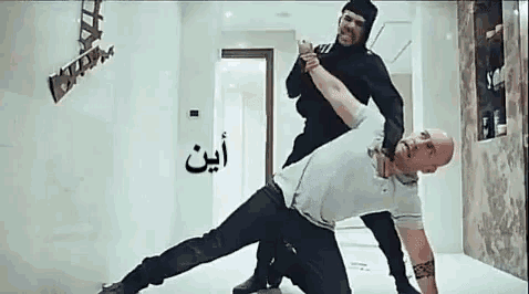 a man in a white shirt is being attacked by a man in a black suit .