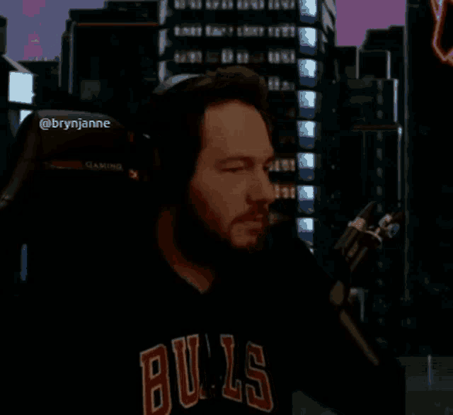 a man wearing headphones and a bulls shirt is giving a thumbs up