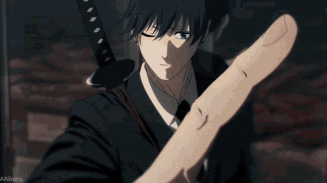 a man is holding a sword with his fingers crossed in front of him