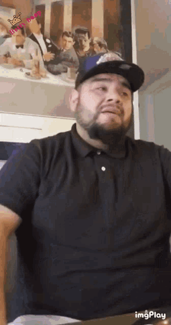 a man with a beard is wearing a hat and a black shirt ..