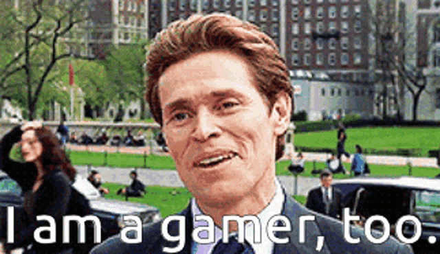 a man in a suit and tie with the words i am a gamer too