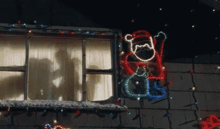 a shadow of a person is cast on a window with christmas lights on