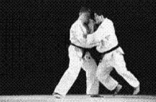 a black and white photo of two men fighting each other in judo .