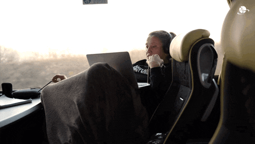 a woman wearing headphones is using a laptop computer