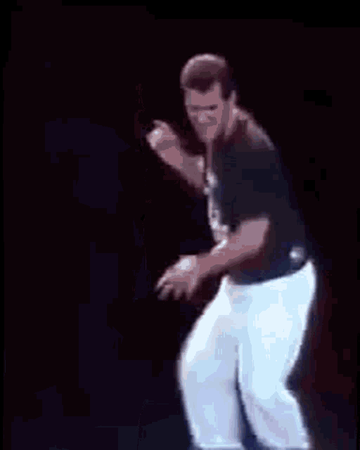 a man is dancing on a stage in a dark room .