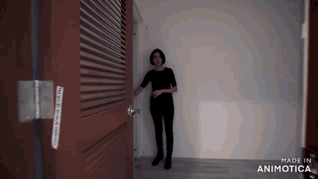 a woman stands in front of a door that says made in animatica