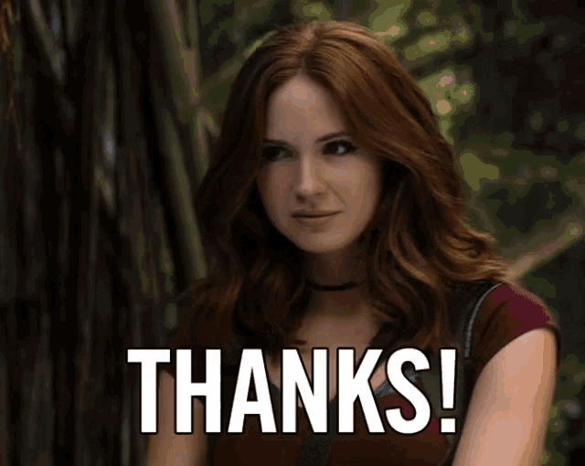 a woman with red hair is giving a thanks gesture