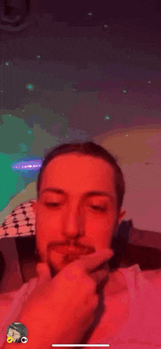 a man with a beard is giving a thumbs up in front of a colorful background