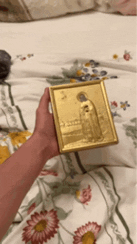 a person is holding a picture of a woman in a gold frame