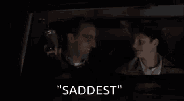 a man and a boy are laughing in a car and the boy is saying " saddest "